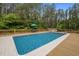 Inviting in-ground pool surrounded by wooden decking and lush greenery, perfect for outdoor relaxation and entertainment at 3653 Range Rd, Stem, NC 27581