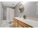Well-lit bathroom featuring a shower-tub combo, round mirror and a vanity with storage at 45 Iris Dr, Youngsville, NC 27596