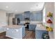 Modern kitchen featuring sleek granite countertops, a large island, stainless steel appliances, and stylish blue cabinetry at 45 Iris Dr, Youngsville, NC 27596