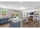 Bright kitchen with a granite island, stainless appliances, and dining area, seamlessly flowing into the adjacent living room at 45 Iris Dr, Youngsville, NC 27596