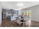 A well-lit kitchen featuring blue cabinets, stainless appliances, a granite island, and an adjacent dining area at 45 Iris Dr, Youngsville, NC 27596