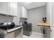 Well-equipped laundry room with modern washer, dryer, and convenient folding station at 45 Iris Dr, Youngsville, NC 27596