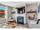 Cozy living room with a fireplace, a stylish mantel, a large screen TV, and a mix of modern and rustic décor at 45 Iris Dr, Youngsville, NC 27596