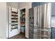 An organized pantry is next to a stainless refrigerator, offering ample storage space in this functional kitchen area at 45 Iris Dr, Youngsville, NC 27596
