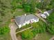 Aerial view of the property showcasing the landscaped grounds, and charming white home at 4830 North Hills, Raleigh, NC 27612