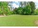 Spacious green lawn with mature trees, offering a serene and private backyard setting at 4830 North Hills, Raleigh, NC 27612