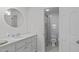 Bright bathroom with a round mirror, sink, and walk-in shower at 4830 North Hills, Raleigh, NC 27612