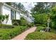 Picturesque exterior of a white brick home, showcasing a brick path and manicured greenery at 4830 North Hills, Raleigh, NC 27612