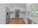 Updated kitchen with stainless appliances, white cabinetry, tile backsplash and a view of the backyard at 4830 North Hills, Raleigh, NC 27612