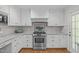 Bright kitchen featuring white cabinets, granite countertops, stainless steel appliances, and hardwood floors at 4830 North Hills, Raleigh, NC 27612