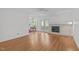 Open living room featuring a brick fireplace, hardwood floors, ceiling fan, and access to the outdoor patio at 4830 North Hills, Raleigh, NC 27612
