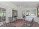 Relaxing sunroom with brick flooring, multiple windows, and a ceiling fan at 4830 North Hills, Raleigh, NC 27612