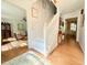 Bright entryway with a white staircase, hardwood floors, and a view into the living room at 5021 Lansdowne Dr, Durham, NC 27712