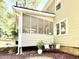 Exterior view of a house with a screened-in porch, a bench, and a well-maintained yard at 5021 Lansdowne Dr, Durham, NC 27712