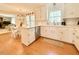 Open kitchen with an island, white cabinets, stainless steel appliances and a view to the living room at 5021 Lansdowne Dr, Durham, NC 27712