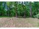 Backyard featuring mature trees, lawn chairs, and a fire pit at 603 Gentry Ln, Hillsborough, NC 27278