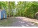 Spacious backyard area with shed and covered structure surrounded by lush trees at 603 Gentry Ln, Hillsborough, NC 27278