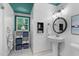 Bright, modern bathroom features sleek fixtures, pedestal sink, decorative shelving, and ample storage at 603 Gentry Ln, Hillsborough, NC 27278