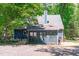 Charming home with blue siding, a chimney, and many windows nestled amongst lush trees at 603 Gentry Ln, Hillsborough, NC 27278