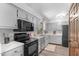 Bright kitchen with stainless appliances, light gray cabinets, dark oven, and durable modern flooring at 603 Gentry Ln, Hillsborough, NC 27278