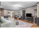 Bright living room with hardwood floors, gray trim, modern lighting, and comfortable seating near a brick fireplace at 603 Gentry Ln, Hillsborough, NC 27278