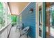 The covered side porch offers a serene outdoor space with quaint seating and natural light at 603 Gentry Ln, Hillsborough, NC 27278
