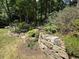 Backyard with stone retaining wall and mature landscaping at 606 Chalice St, Durham, NC 27705
