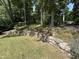 Landscaped backyard features stone retaining walls and manicured plants at 606 Chalice St, Durham, NC 27705
