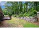 Expansive backyard featuring stone retaining walls, mature trees, and a private, serene setting at 606 Chalice St, Durham, NC 27705
