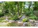 Beautifully landscaped backyard featuring stone retaining walls, mature trees, and a serene garden setting at 606 Chalice St, Durham, NC 27705