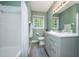 Neutral bathroom featuring a white shower/tub combo, vanity with granite counter and window at 606 Chalice St, Durham, NC 27705