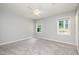 Large bedroom boasting neutral walls, carpet, and two windows flooding the room with natural light at 606 Chalice St, Durham, NC 27705
