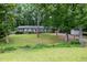 Inviting single-story home with a red door, manicured lawn, and mature trees providing ample shade at 606 Chalice St, Durham, NC 27705