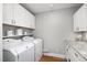 Functional laundry room boasting white cabinets and granite counters and modern washer and dryer at 606 Chalice St, Durham, NC 27705