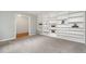 Bright living room with custom built-in shelving, plush carpeting, and a view to the foyer at 606 Chalice St, Durham, NC 27705
