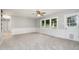 Bright living room featuring a ceiling fan, neutral paint, white wainscoting, and a large window with a view of the trees at 606 Chalice St, Durham, NC 27705