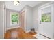 Mudroom with a window, curtain, closet, hardwood floors, and a white door with glass at 606 Chalice St, Durham, NC 27705