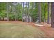 Backyard featuring play area, shed and swing surrounded by mature trees and grass at 640 St Vincent Dr, Holly Springs, NC 27540