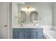 Bathroom featuring a double vanity with framed mirrors and modern lighting fixtures at 640 St Vincent Dr, Holly Springs, NC 27540