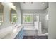 Bathroom features double vanity with blue cabinets, soaking tub, and separate glass shower at 640 St Vincent Dr, Holly Springs, NC 27540