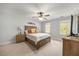Bright bedroom features neutral tones, a ceiling fan, and a comfortable wooden bed frame at 640 St Vincent Dr, Holly Springs, NC 27540
