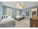 Cozy bedroom with two twin beds, ceiling fan and windows with views of the outdoor landscape at 640 St Vincent Dr, Holly Springs, NC 27540
