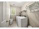 Convenient laundry room with white appliances, shelving, and a window for natural light at 640 St Vincent Dr, Holly Springs, NC 27540