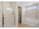 Clean and updated bathroom with separate shower and garden tub with neutral toned tile flooring at 713 Apalachia Lake Dr, Fuquay Varina, NC 27526