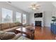 Cozy living room with a fireplace, large windows, hardwood floors, and comfortable seating at 713 Apalachia Lake Dr, Fuquay Varina, NC 27526