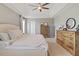 Spacious primary bedroom with neutral tones, featuring a ceiling fan and ample natural light with a dresser at 713 Apalachia Lake Dr, Fuquay Varina, NC 27526