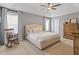 Bright primary bedroom with large windows, seating area, and neutral tones, with a ceiling fan at 713 Apalachia Lake Dr, Fuquay Varina, NC 27526