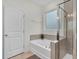 Bathroom featuring tile flooring, glass shower, bathtub and frosted window at 74 Hidden Grove Ct, Garner, NC 27529