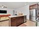 Kitchen island with bar seating, wooden cabinets, granite counters and stainless steel appliances at 74 Hidden Grove Ct, Garner, NC 27529