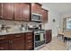 Modern kitchen features wood cabinets, stainless steel appliances, tile backsplash, and granite countertops at 74 Hidden Grove Ct, Garner, NC 27529